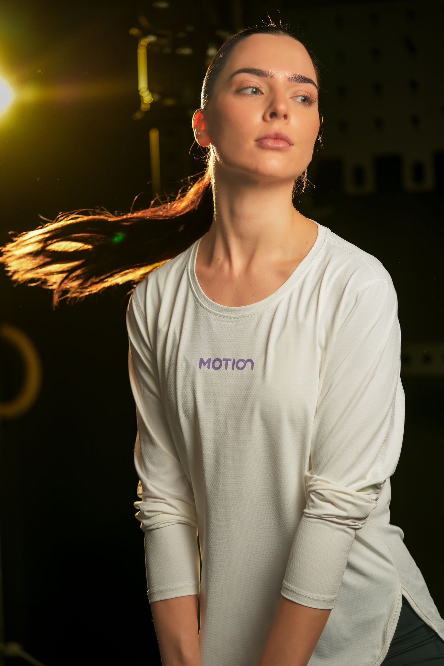 Model wearing the best workout clothes for women, including a white Motion long-sleeve top, ideal for fitness and gym sessions